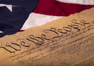The constitution with an American flag in the background.